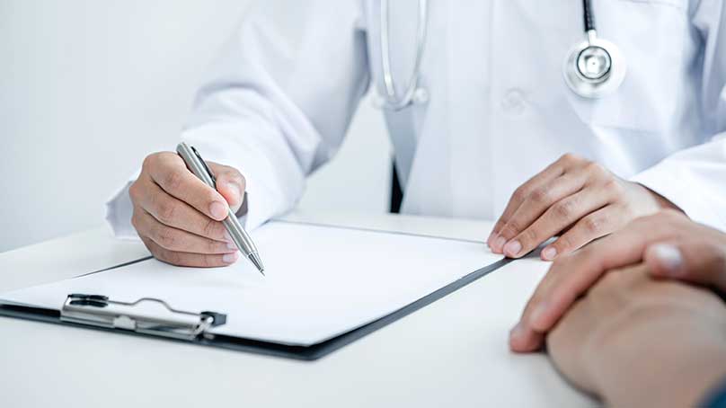 Консультація судинного хірурга у клініці: лікар заповнює медичну документацію